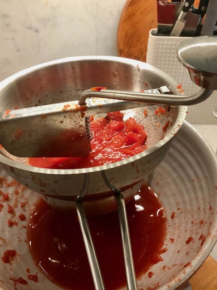 Pureeing the tomatoes with a food mill